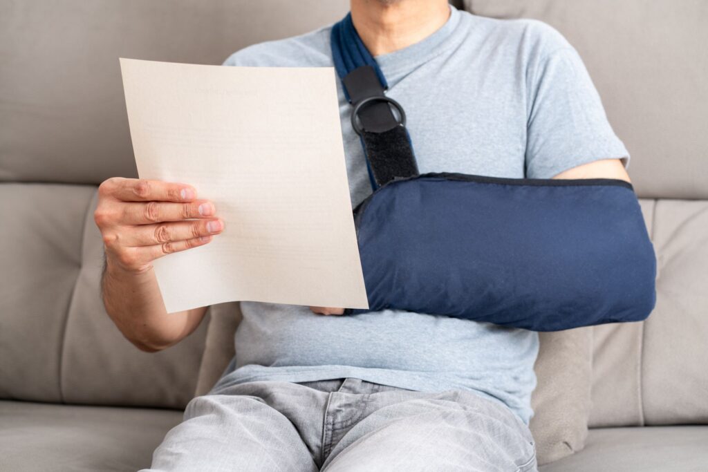 A car accident victim in Utah reviews his PIP insurance policy while recovering from an arm injury.