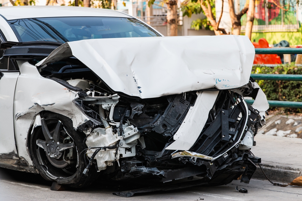 A detailed view of a car accident showcasing the extensive damage in an urban environment.