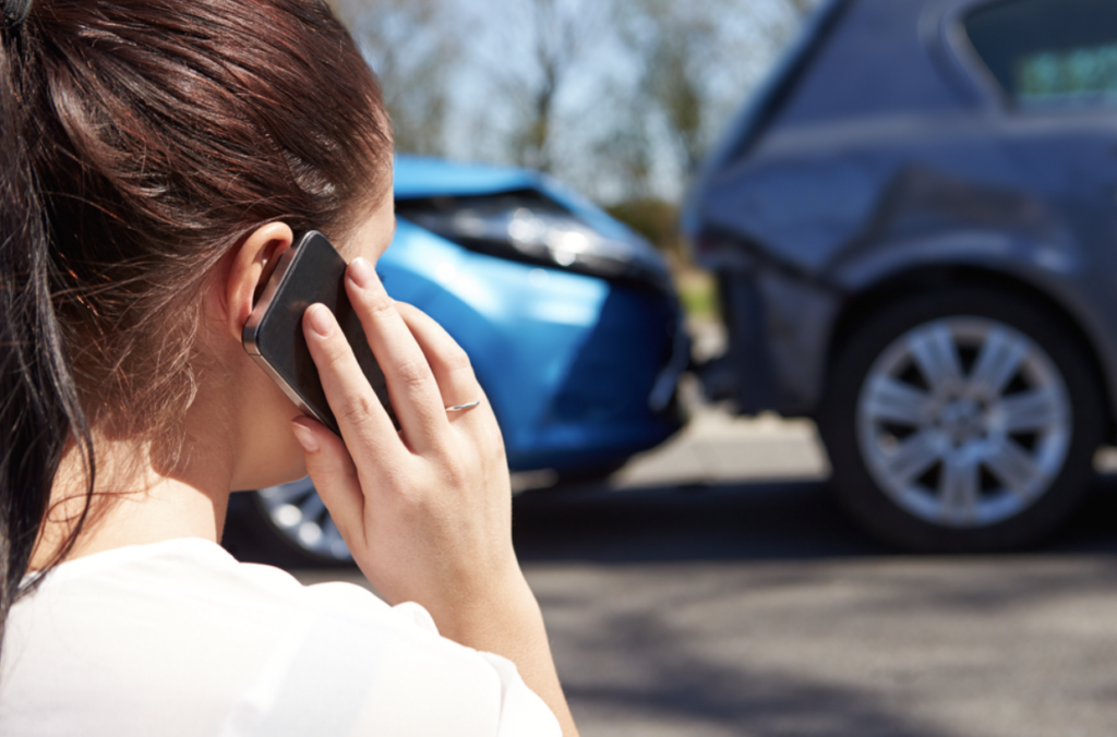A woman on her cell phone after a car accident