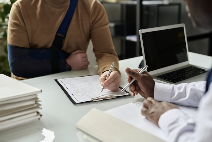 Person in arm sling filling out medical forms