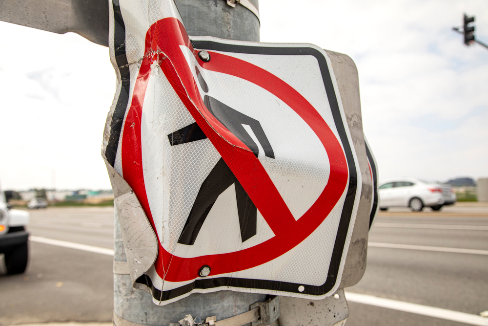 A no pedestrian crossing sign that was damaged due to a car accident