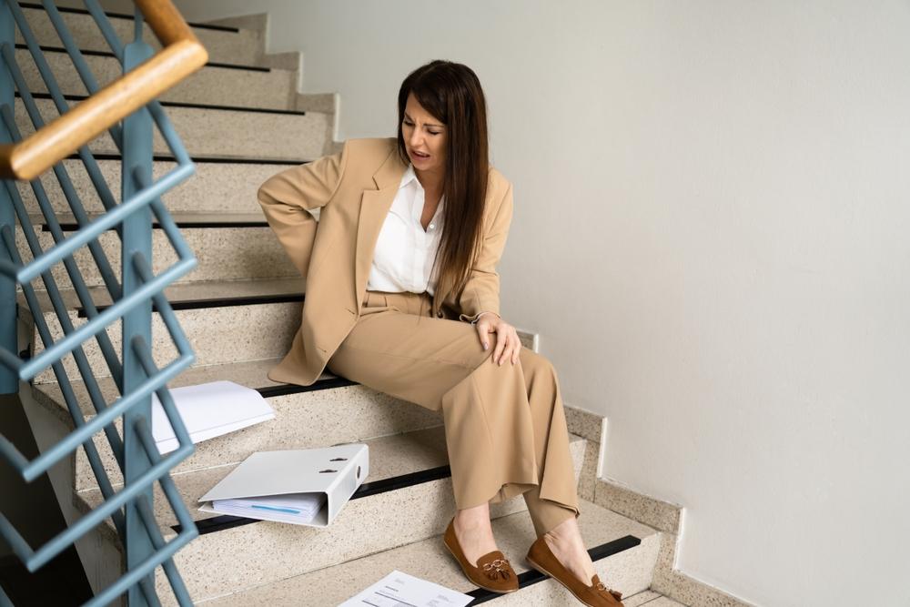 Slip And Fall Accident On Stairs. Worker Woman Fallen Down