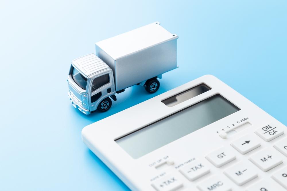 Truck and calculator on blue background.