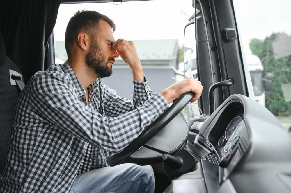 Portrait of tired truck driver feeling sleepy and sick