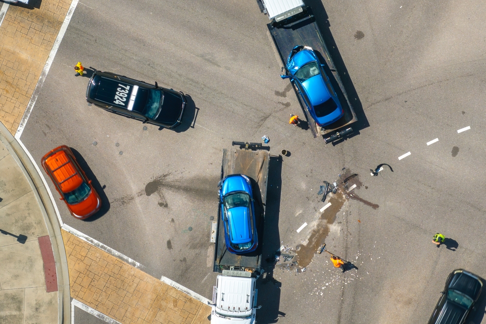 First responders helping on car accident site. Tow truck loading crashed car. Emergency services responding to vehicle crash on American street