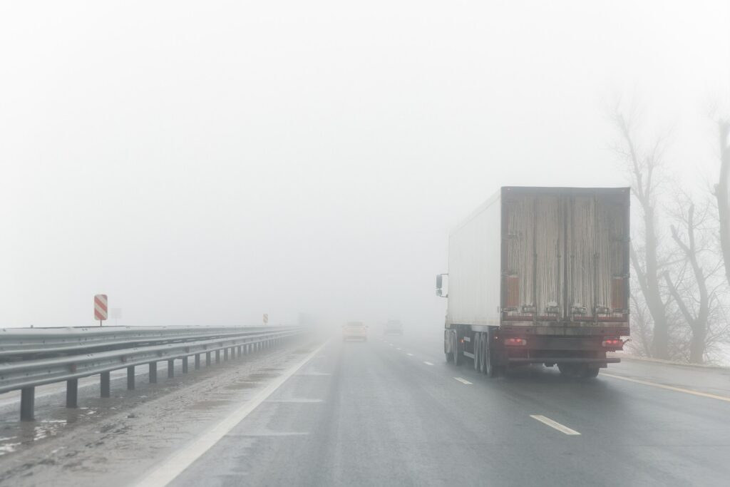 Rear view of a truck on I-80 showing blind spot liability warnings.