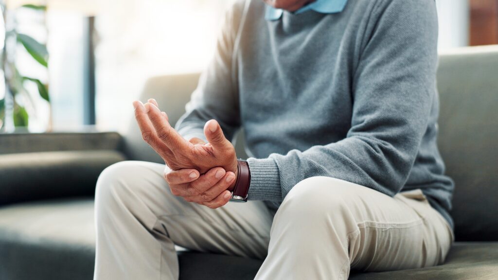Injured man holding his wrist while seated indoors, representing common Midvale apartment injury cases where tenants may sue a landlord for unsafe conditions.