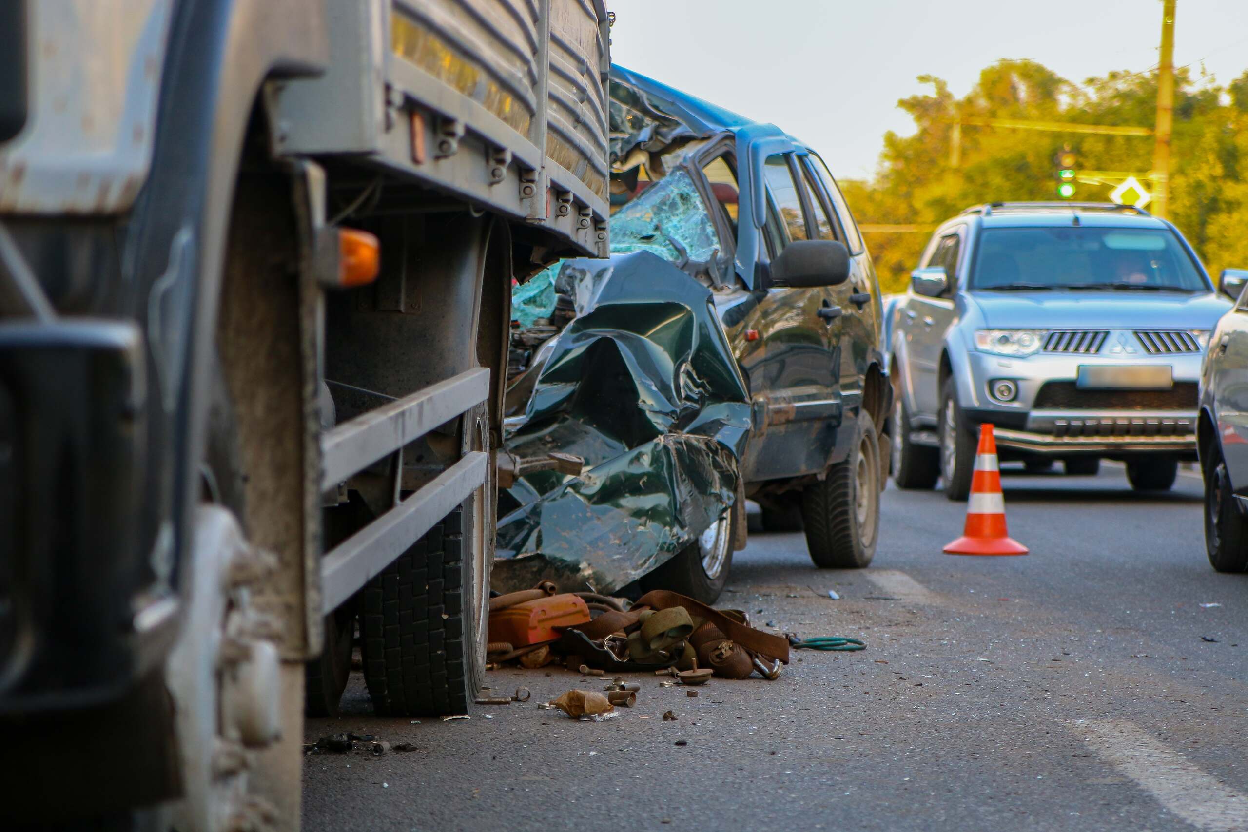 Severely damaged SUV after collision with a commercial truck, illustrating liability issues involving unsecured truck loads and falling cargo in Midvale.