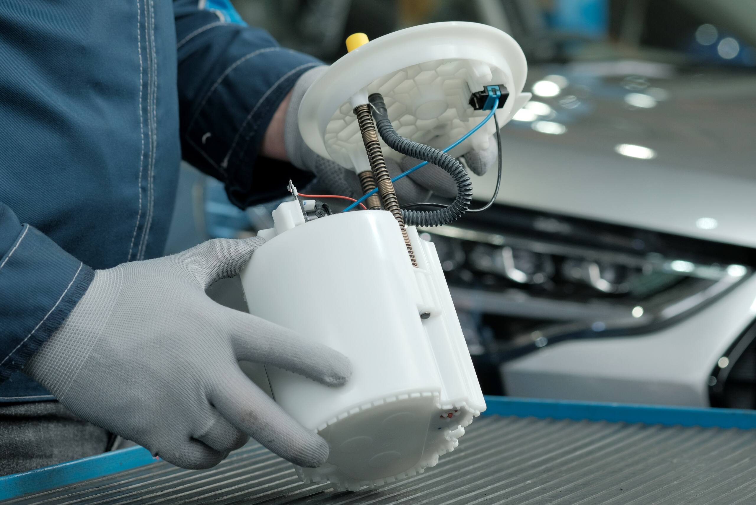 Mechanic holding defective auto fuel pump component related to Product Liability in Utah when dangerous products cause serious injuries in Midvale