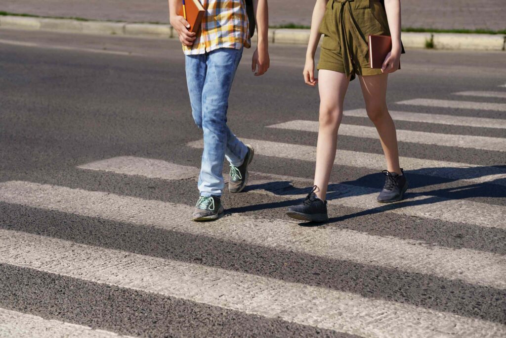 Students using a crosswalk near campus, highlighting the risk of pedestrian accidents and the need to determine UVU vs. city liability.