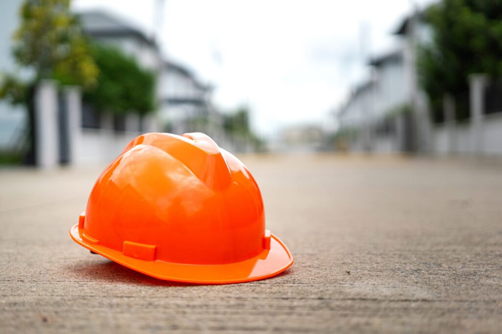 An orange hard hat left on a concrete surface at an Ogden construction site, symbolizing subcontractor injuries and site negligence.