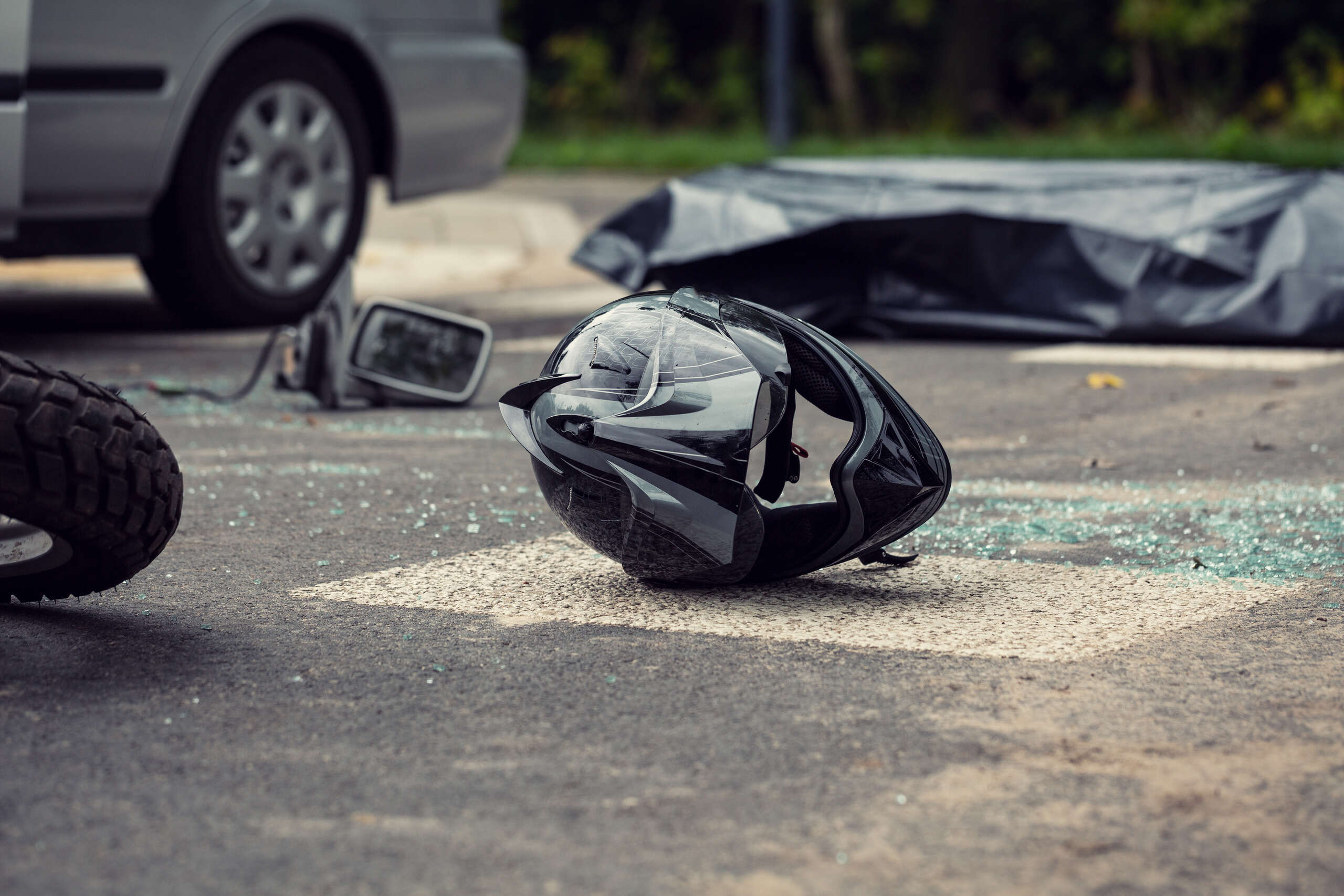 Damaged motorcycle helmet at an Ogden accident scene highlighting the risk of severe road rash injuries.