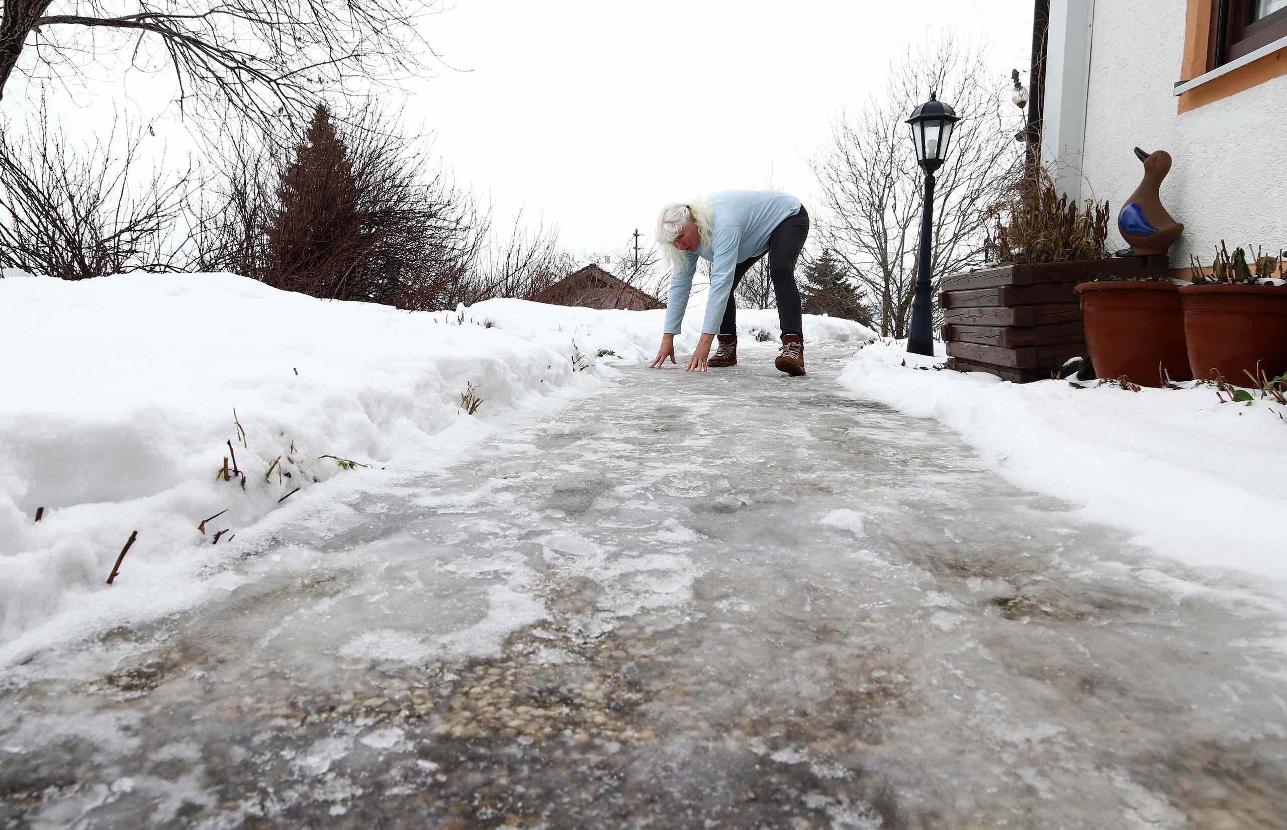 A woman losing her footing on a thick layer of ice covering a private walkway in Ogden.