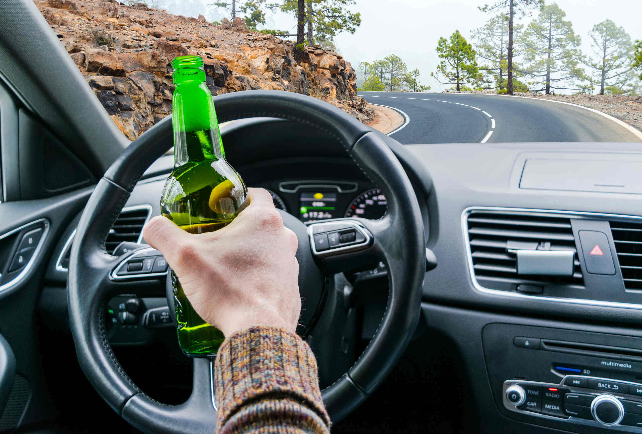 Drunk driver holding a beer while operating a vehicle near BYU in Provo, illustrating a DUI accident claim.