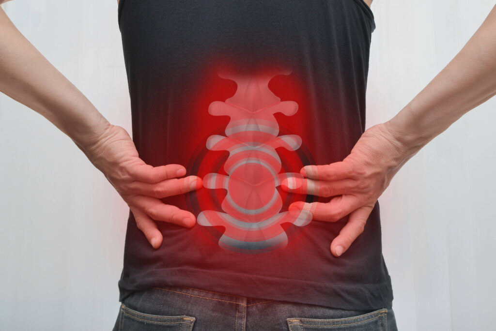 A person’s back with a red, glowing digital overlay highlighting the spine to represent a spinal cord injury or chronic back pain.