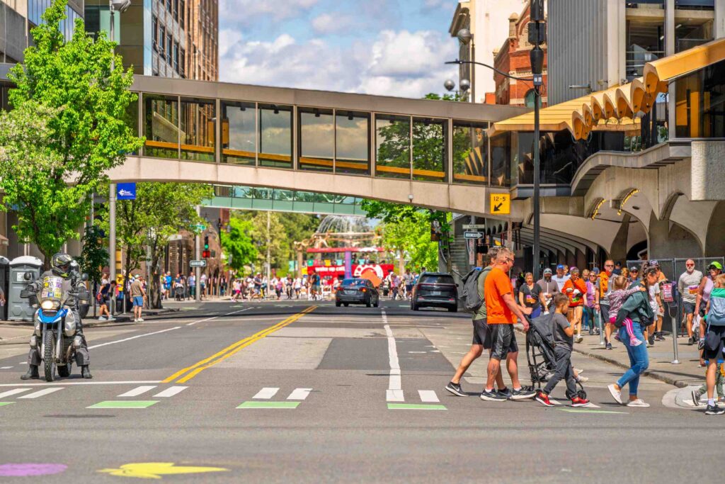 Pedestrians walking across a busy city street in downtown Spokane highlights the service area for Spokane Pedestrian Accident Lawyers.