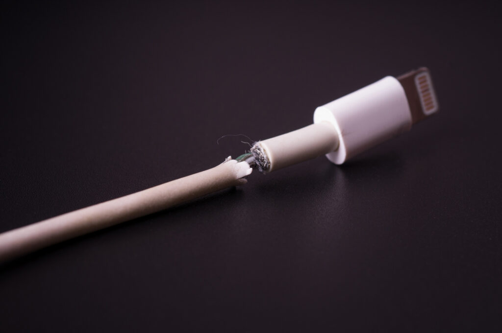 A damaged white charging cable with frayed wires illustrates defective electronics cases handled by Spokane Product Liability Lawyers.