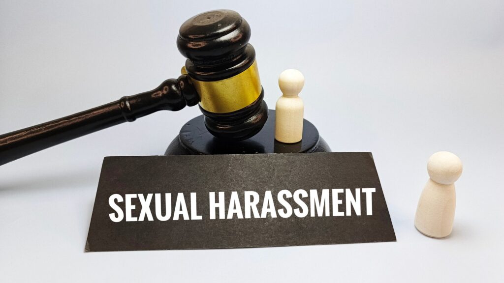 A judge gavel next to a sign reading Sexual Harassment represents claims handled by Utah Sexual Abuse Lawyers.